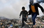 Un homme équipé d’un masque à gaz et un jeune garçon courent dans une rue d’Alep, dans le nord de la Syrie, en mars 2013.