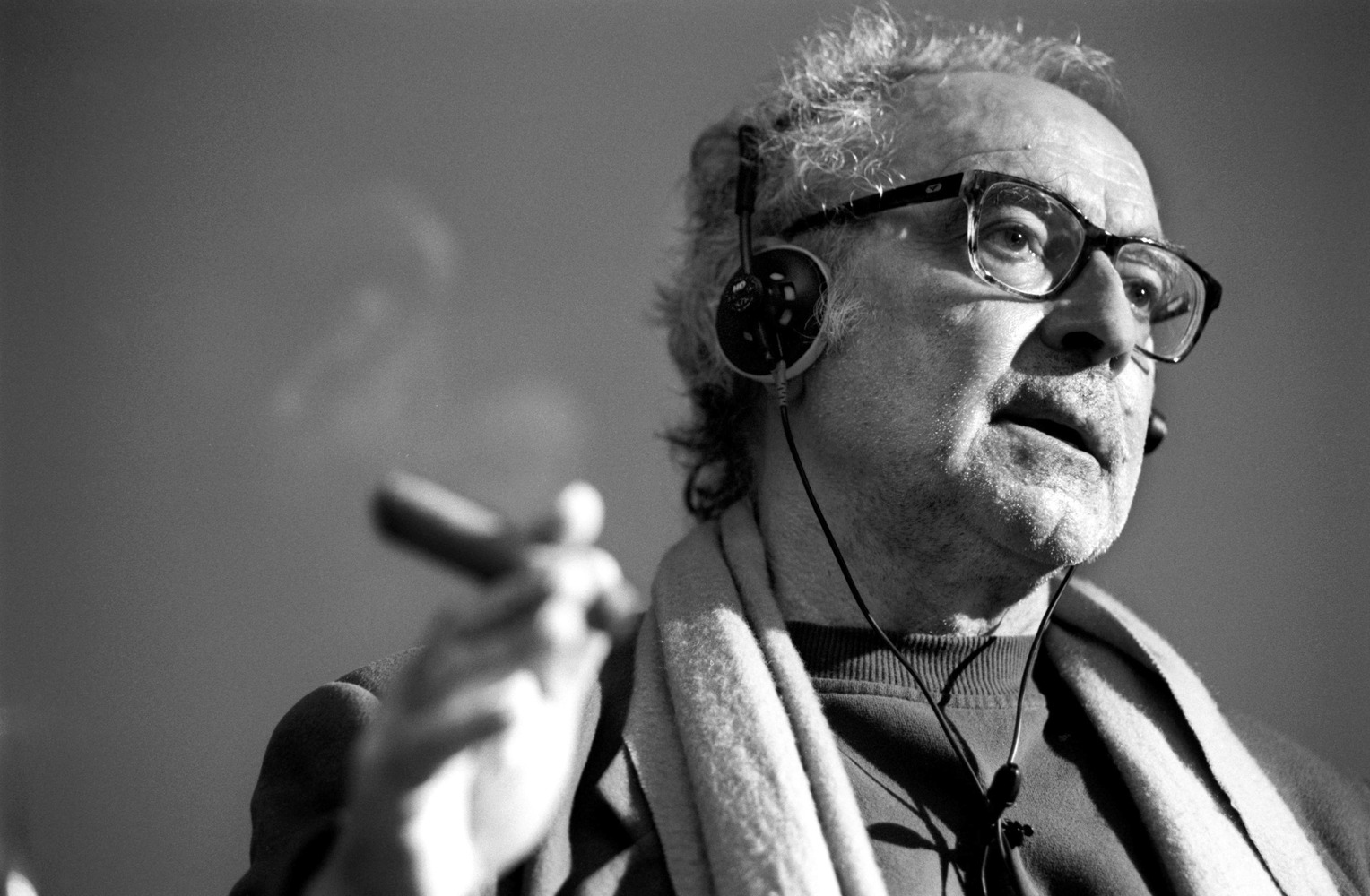 Portait du cinéaste Jean-Luc Godard écoutant de la musique.