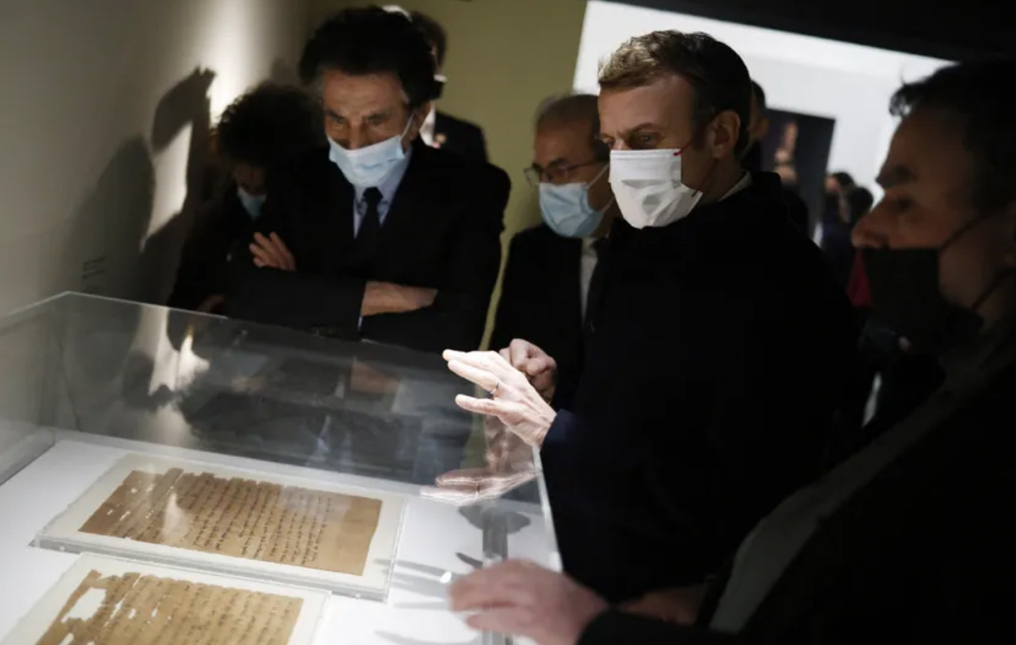 Jack Lang, Emmanuel Macron et Benjamin Stora regardent un document d'archives à l'exposition "Juifs d'Orient".