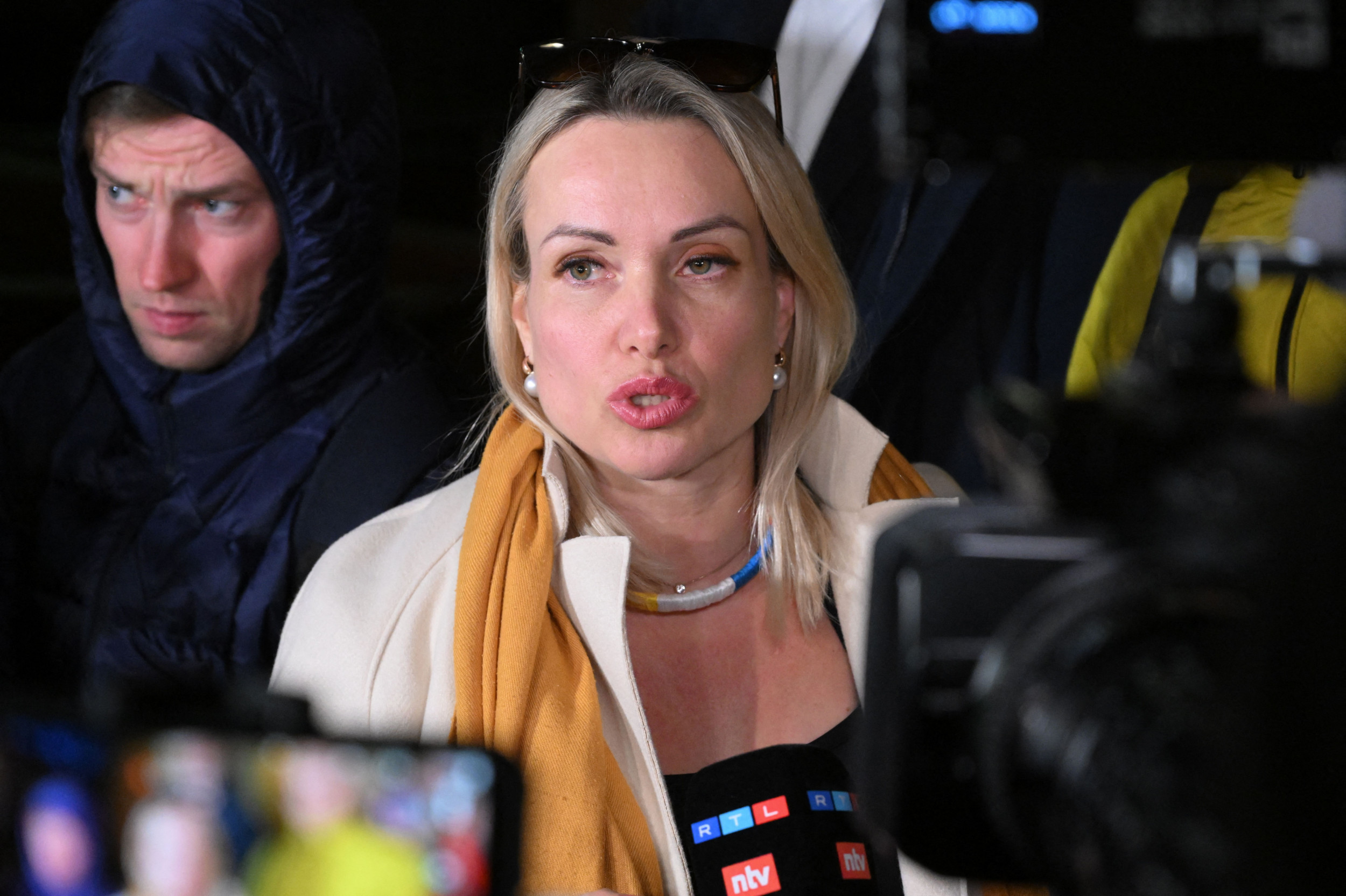 Marina Ovsyannikova, la journaliste et productrice russe, est entourée de microphones.