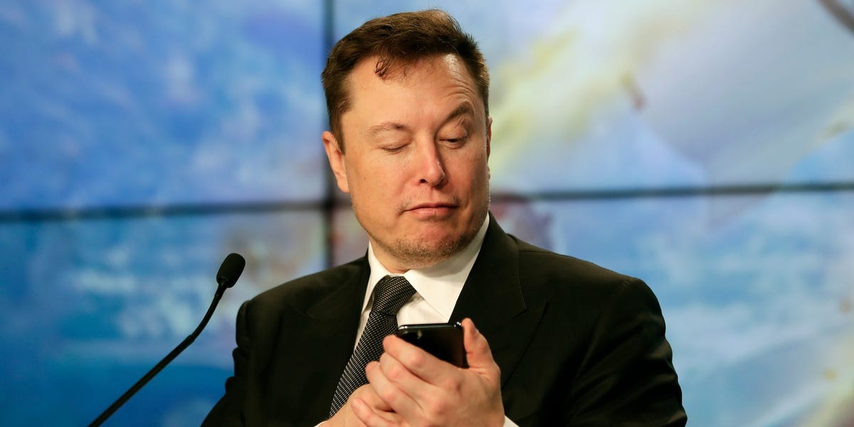 Elon Musk vérifie son compte Twitter lors 'une émission télévisée.