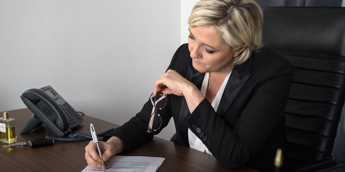 La candidate du Rassemblement national Marine Le Pen., en train d'écrire une lettre au sein du QG de son parti.