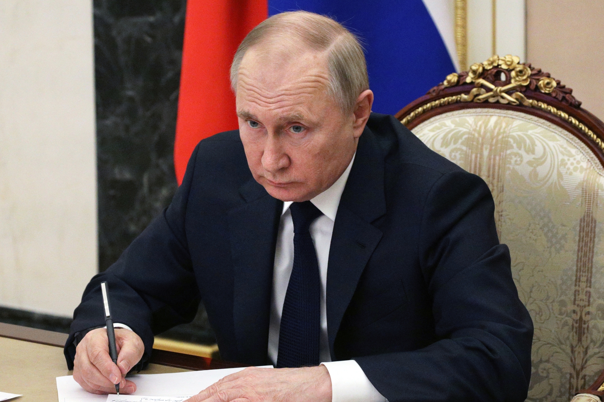 Vladimir Poutine signe un document, à Moscou, le 10 mars 2022.