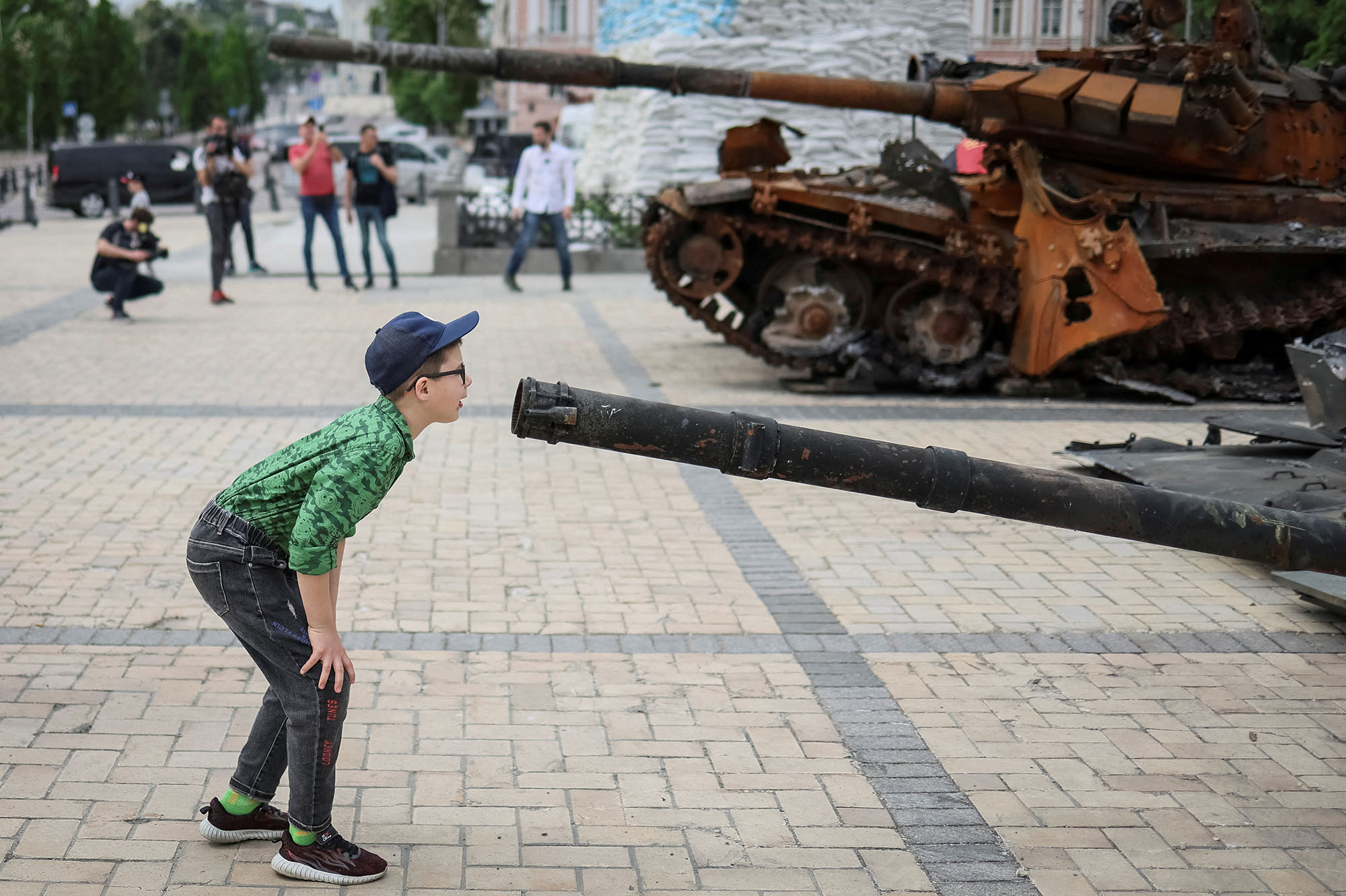 Un garçon regarde un char russe détruit lors d'une exposition présentant des véhicules militaires russes détruits, dans le centre de Kiev, en Ukraine, le 21 mai 2022.