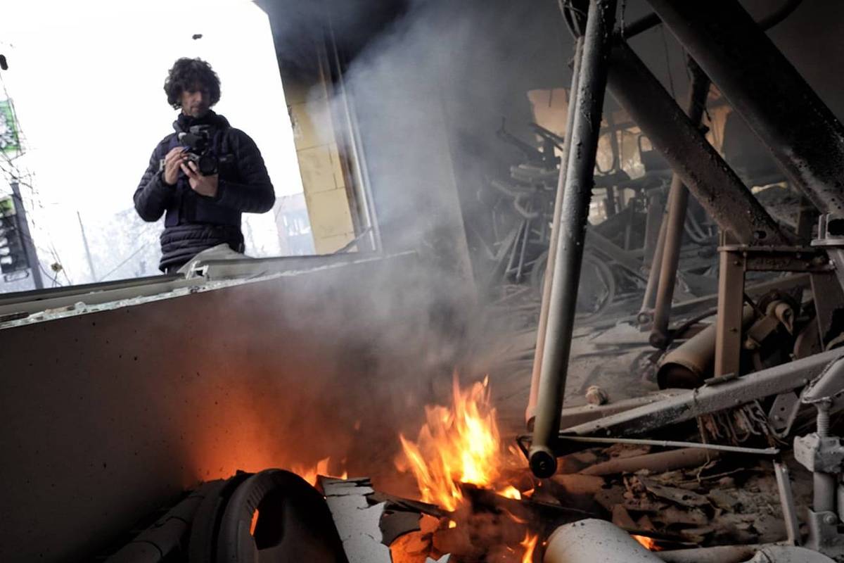 Itai Anghel filme une maison détruite et en feu lors de la Guerre d'Ukraine.