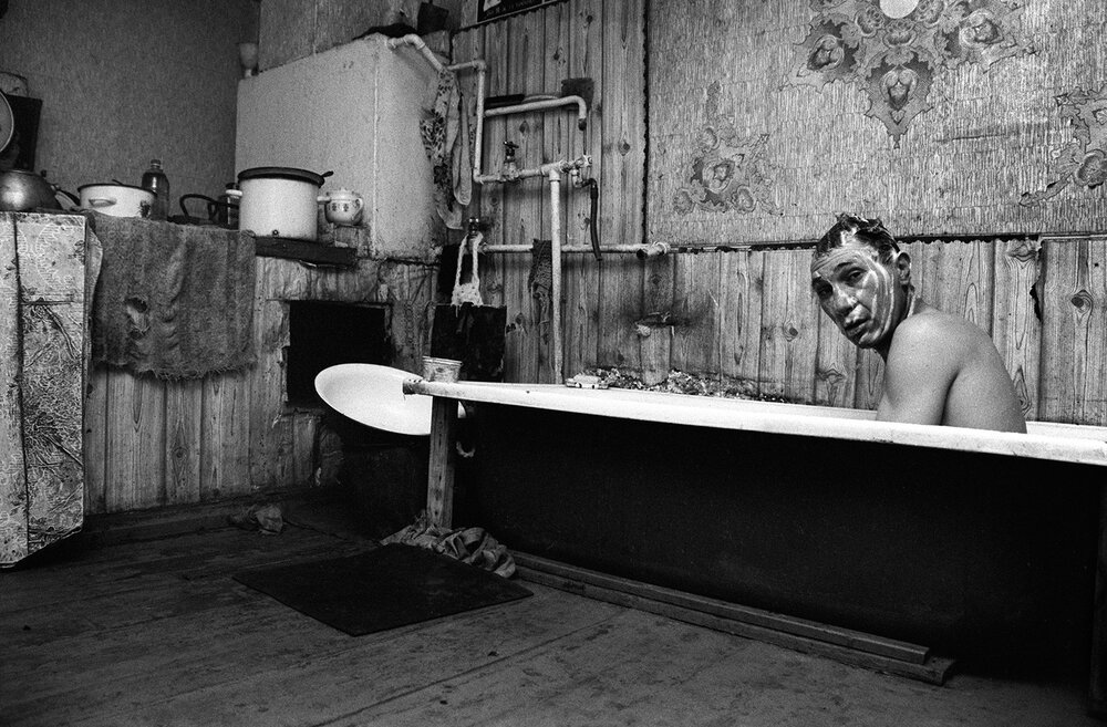 Portrait en noir et blanc d'un hommes dans sa baignoire. Une photographie de Olexandr Tchekmenev, 2016.