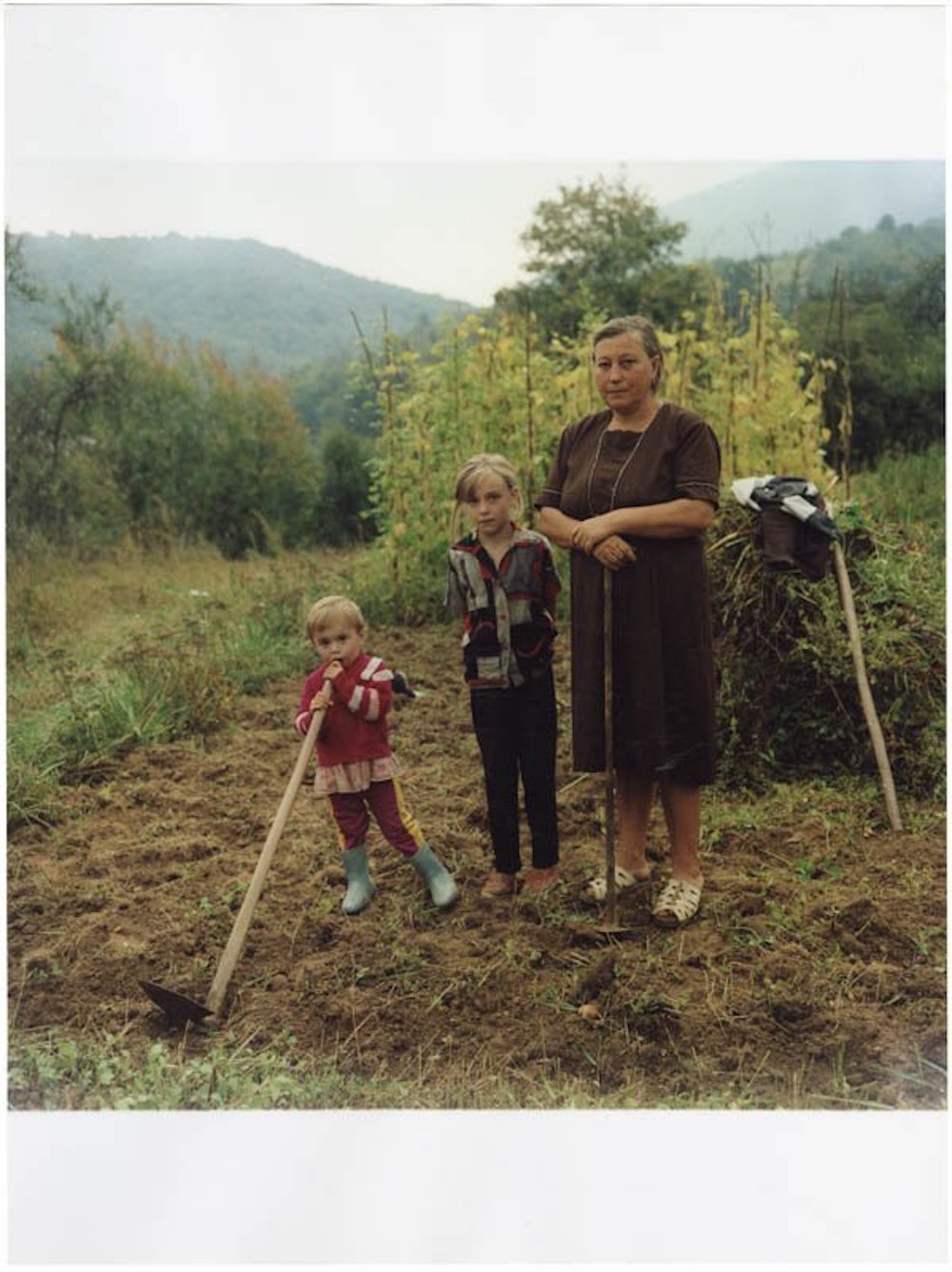 Une femme et ses deux enfants, dans un champ, en Ukraine. Une photo de Yurii Nesterov, prise en 1999.