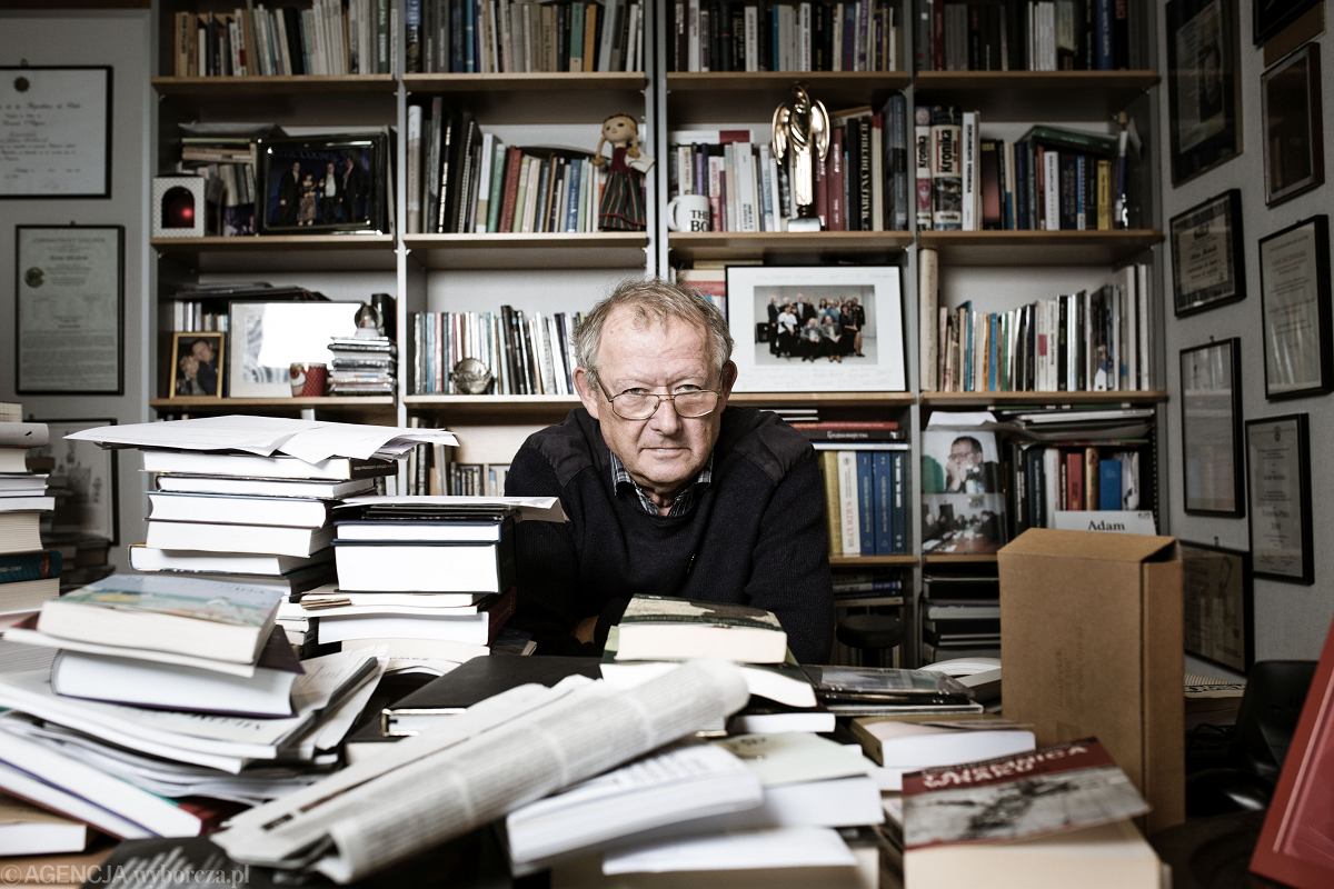 Portrait d'Adam Michnik dans son bureau, entouré de livres.