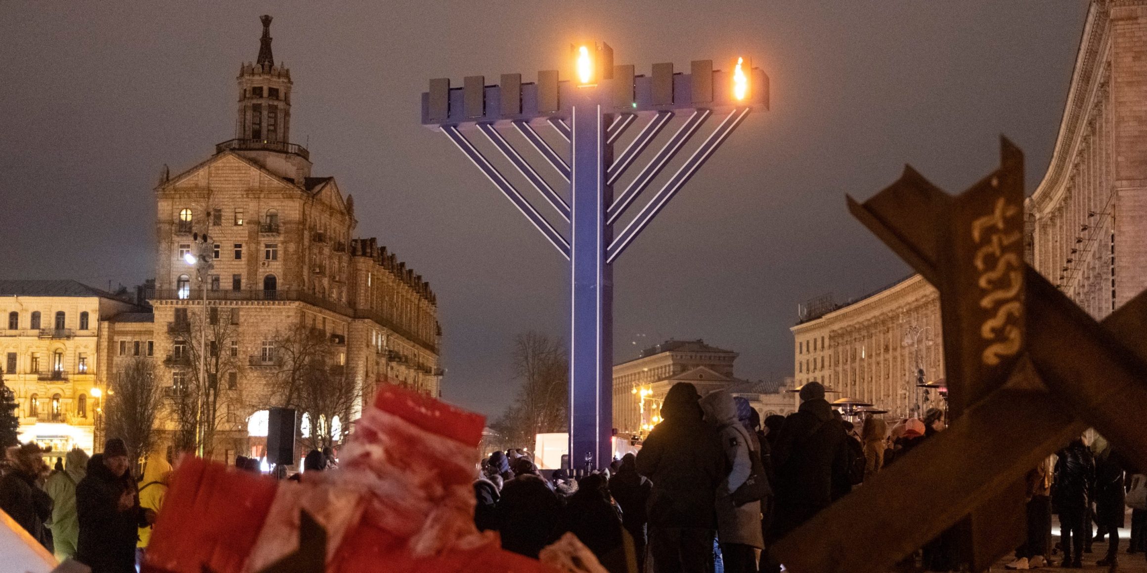 Des membres de la communauté juive se tiennent près d'une hanoukkiah géante lors d'ne cérémonie pour la fête juive de Hanoukka sur le Maïdan, à Kiev, le 18 décembre 2022, alors que le pays subit les attaques russes en Ukraine.