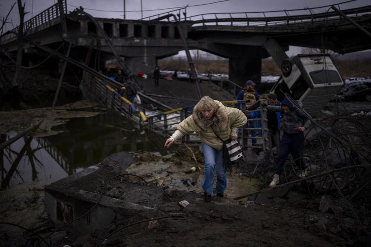 Une femme traverse un pont détruit dans la périphérie de Kiev, en Ukraine, le mercredi 2 mars 2022.