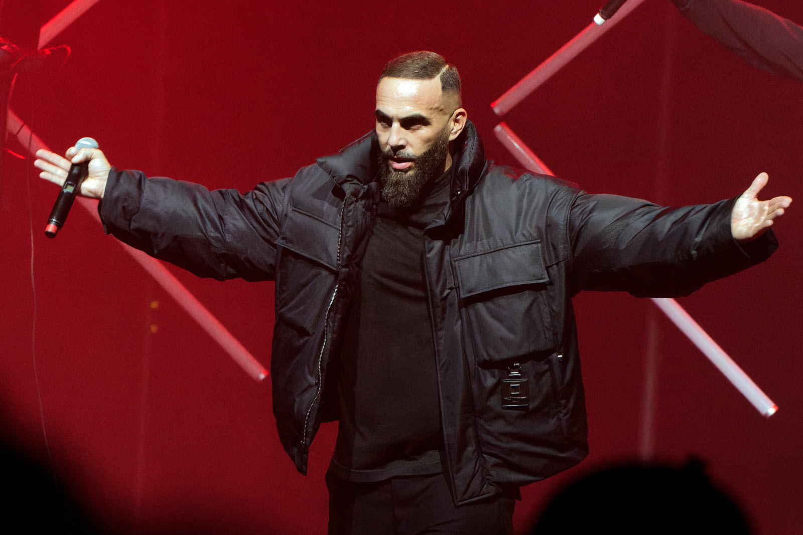 Le rappeur Médine ouvre les bras sur scène, lors d'un concert au Casino de Paris.