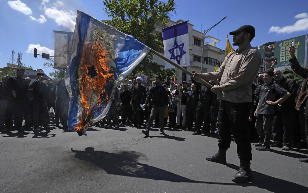 Des manifestants iraniens brûlent les drapeaux israélien et américain lors d'un rassemblement à Téhéran en 2023.