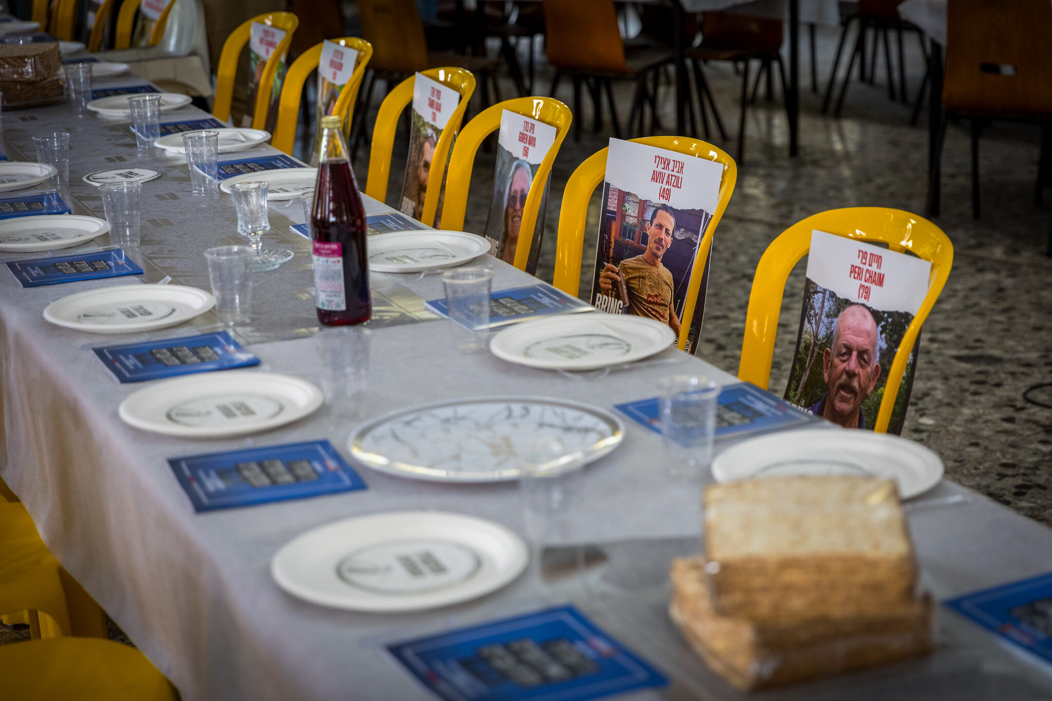 Photos des otages du kibboutz Nir Oz placés sur des chaises et des tables lors d'un événement pré-Pessah, dans la salle à manger du kibboutz le 11 avril 2024.