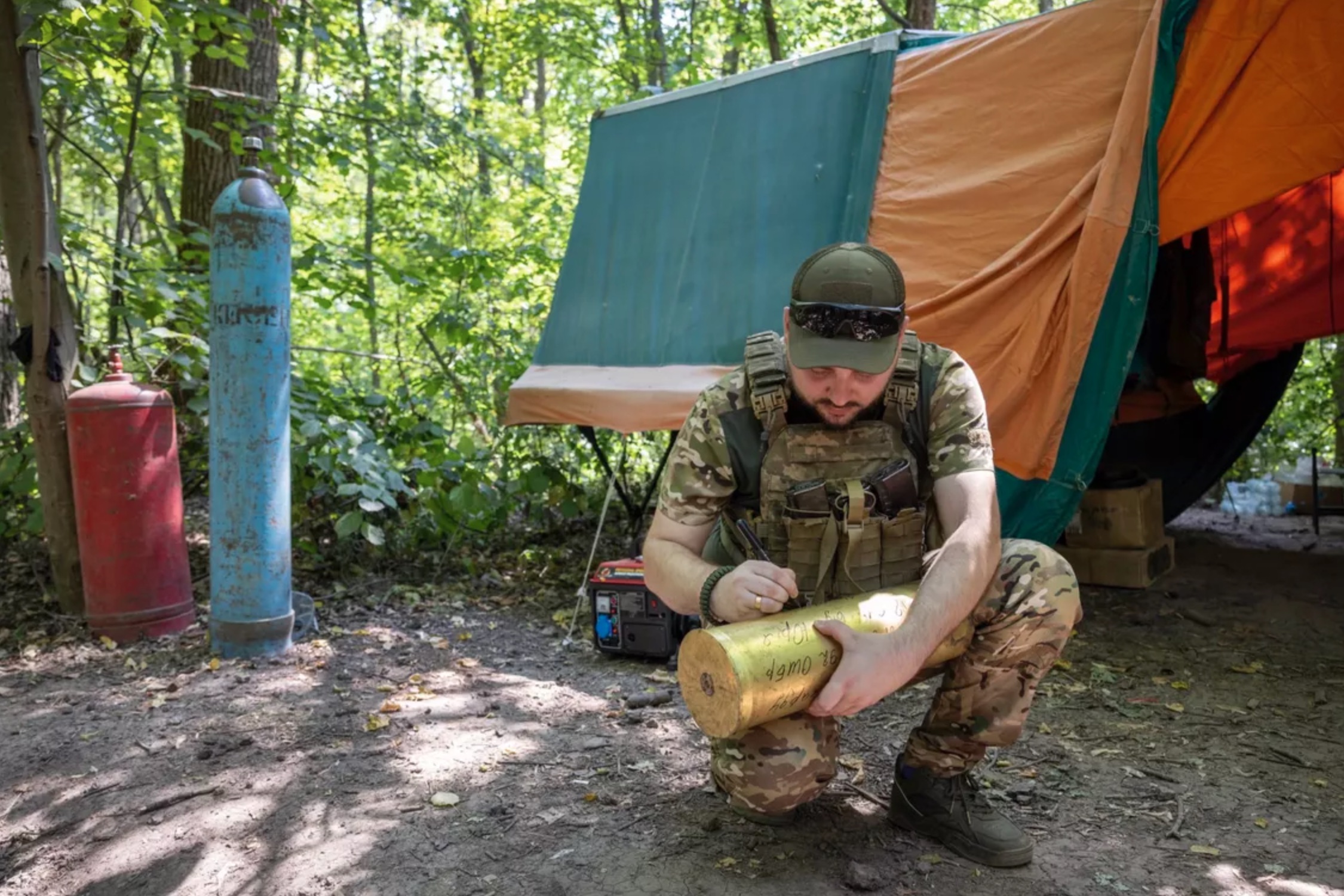 En Ukraine, un sous-officier de la 92e brigade d’assaut écrit un mot de remerciement pour la France sur une douille d’obus de 155.