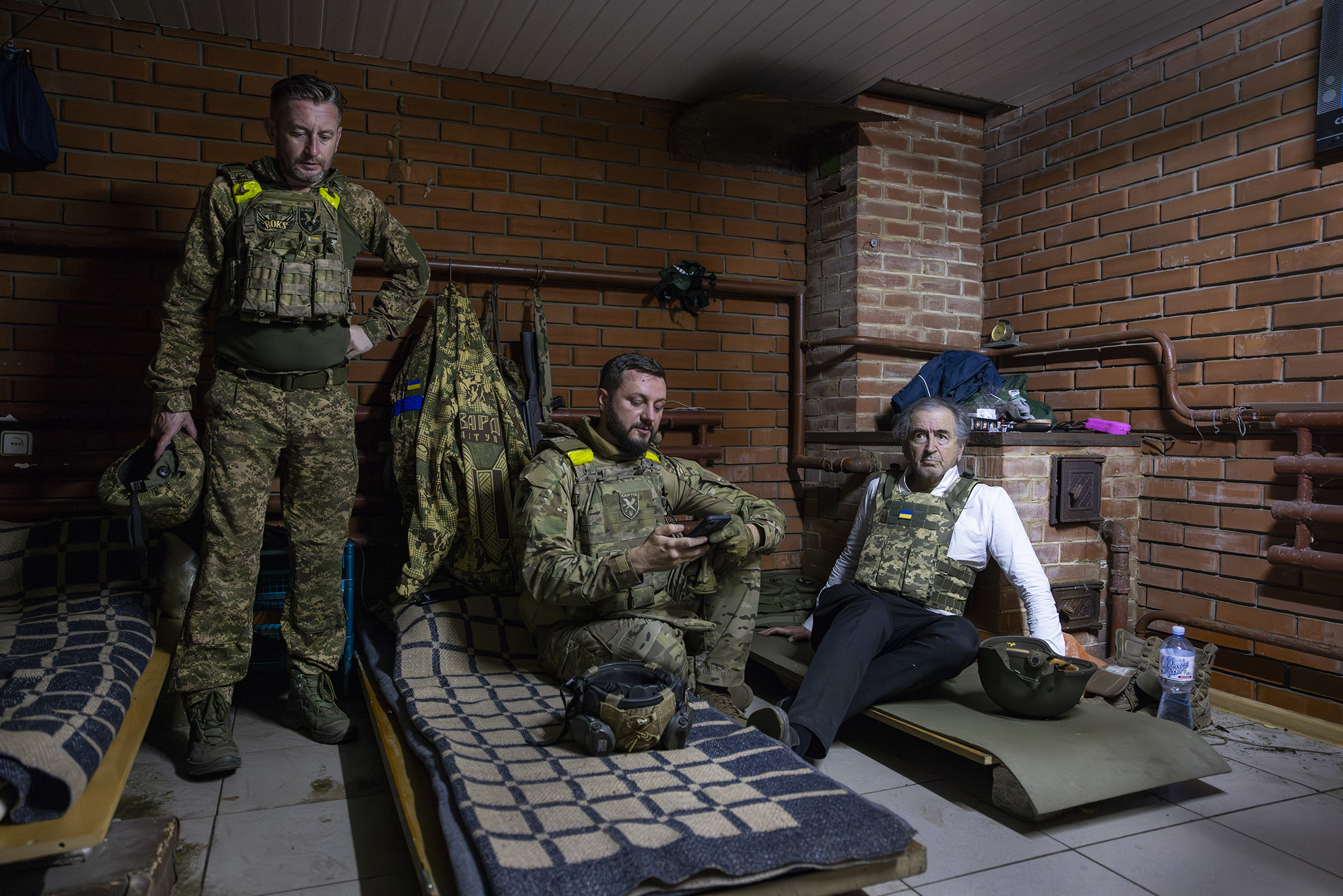 Le poète et écrivain ukrainien Serguei Zhadan, Ihor Obolyenskyi, le chef de la brigade Khartia, et Bernard-Henri Lévy, le 14 juillet, dans un bunker de Kharkiv. Photo : Marc Roussel