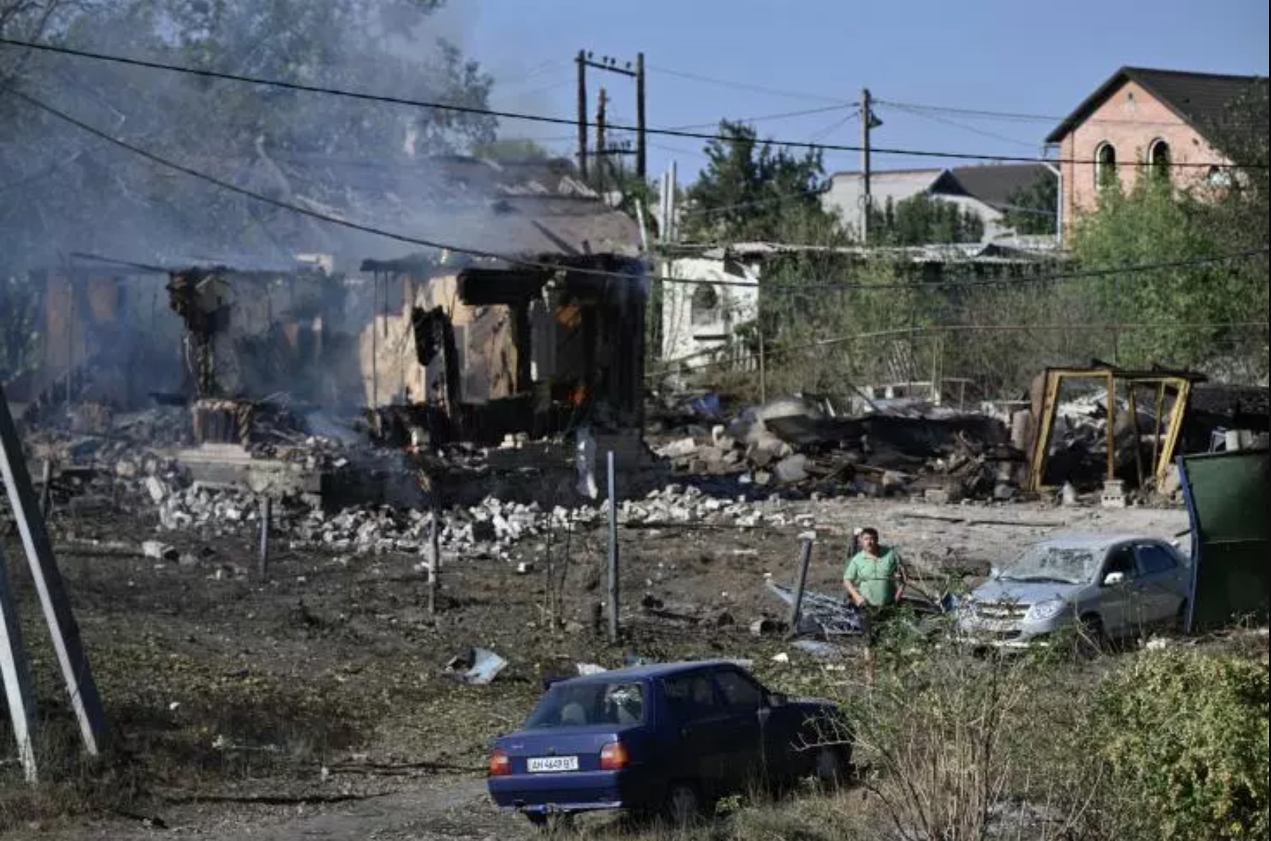 Un homme passe à côté d'une maison incendiée dans la ville de Pokrovsk, dans l'Est de l'Ukraine, après des frappes russes.