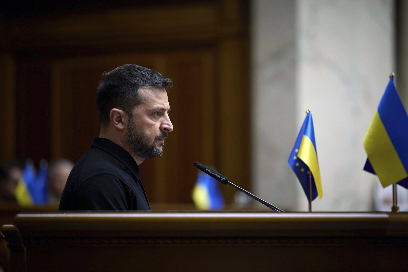 Photo en couleur de Zelensky, le président ukrainien, au Parlement ukrainien, il est seul à prendre la parole devant les députes que l'on ne voit pas à l'image