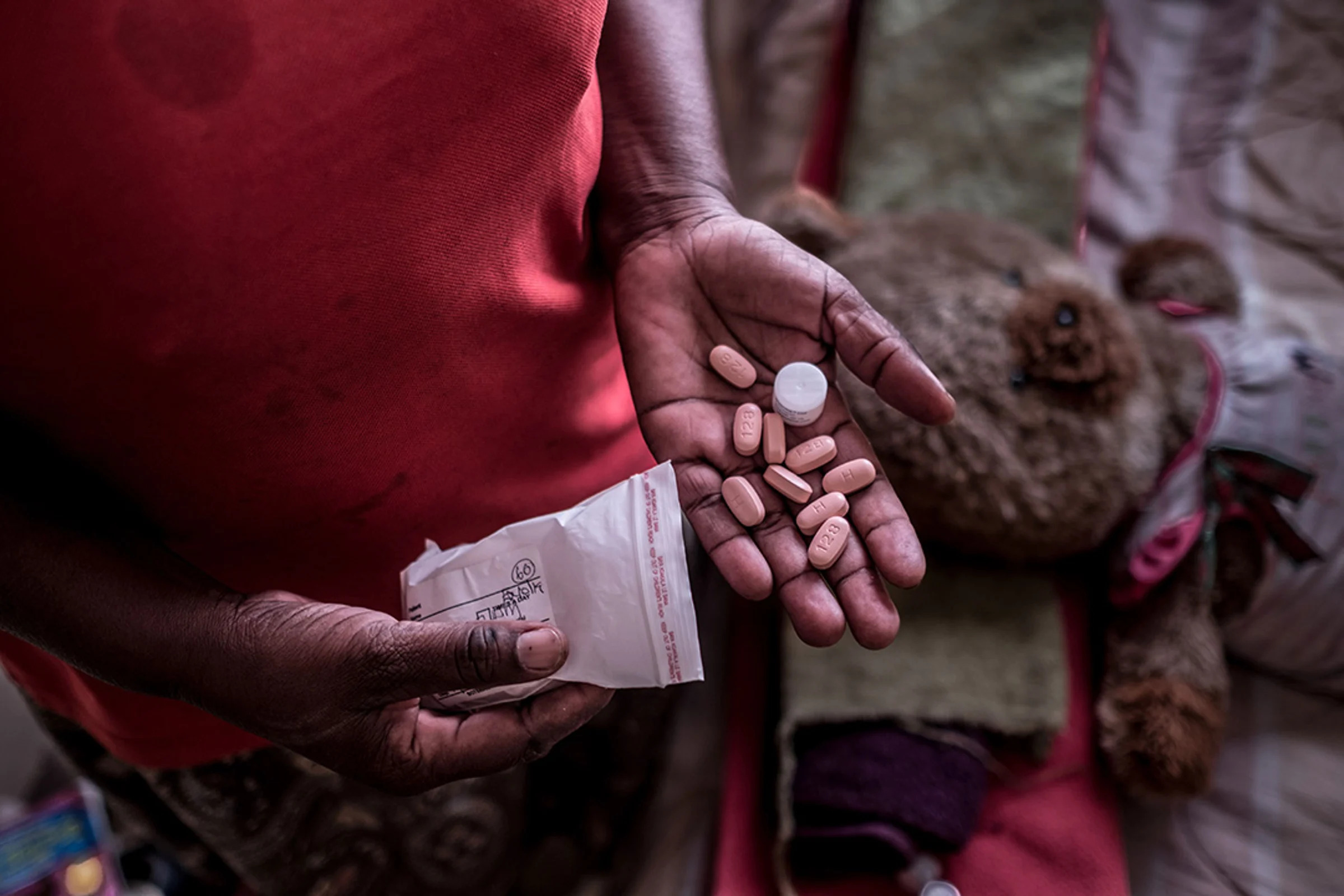 Une femme montre dans sa main des médicaments antirétroviraux pour traiter le Sida