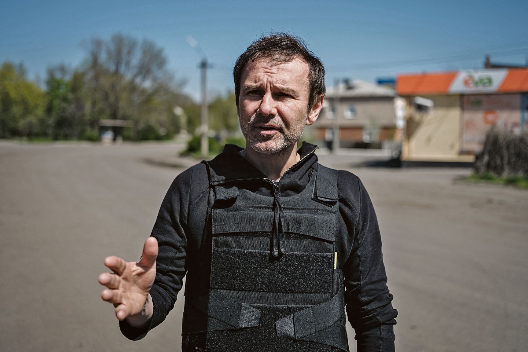 Slava Vakartchouk dans une rue d'un village en ukraine, il parle et porte un gilet-parre-balles