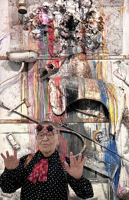 Fernando Arrabal visite l’exposition « Niki de Saint Phalle, Jean Tinguely, Pontus Hulten » au Grand Palais, à Paris. Il pose devant une œuvre de Jean Tinguely.