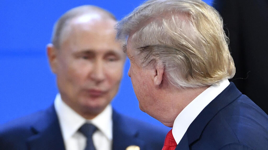 Le président américain Donald Trump (à droite) regarde le président russe Vladimir Poutine alors qu'ils prennent place pour une photo de famille, lors du sommet des dirigeants du G20 à Buenos Aires, le 30 novembre 2018.