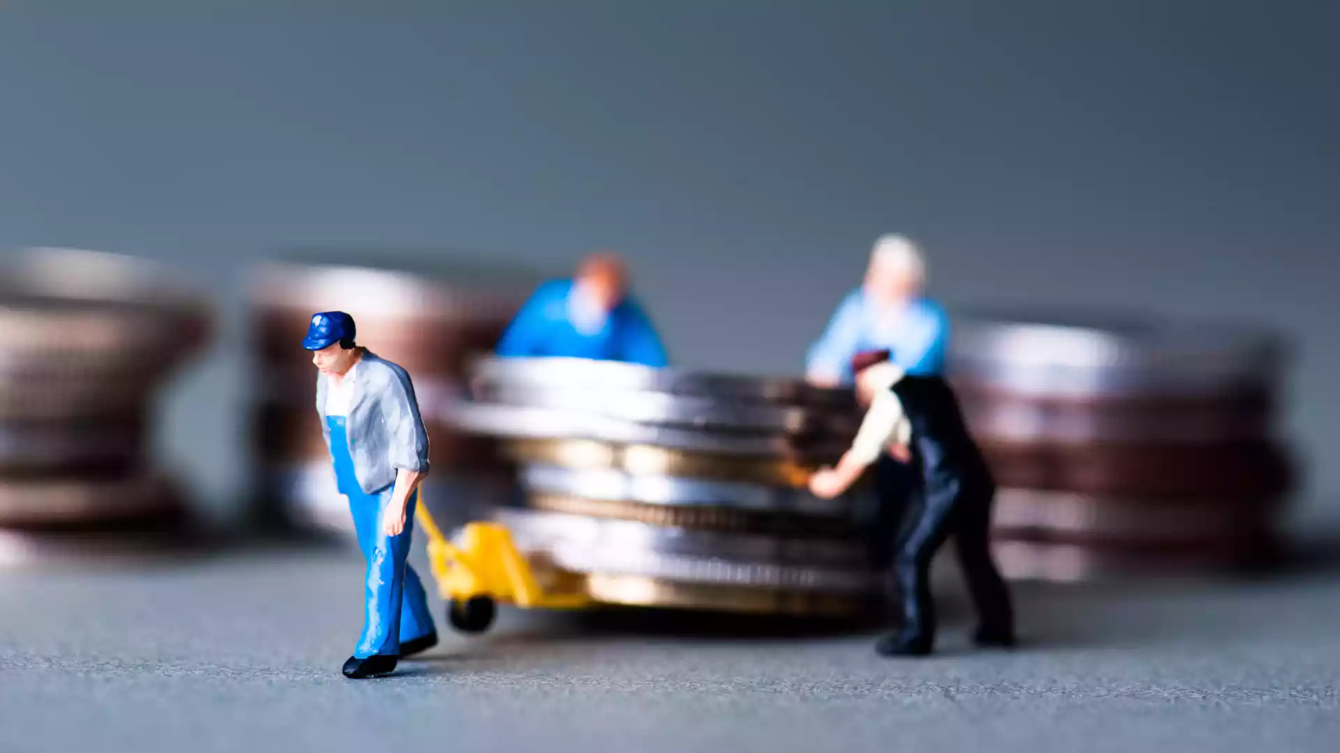 Image représentant de petites figurines en plomb d’ouvriers transportant des pièces de monnaie.