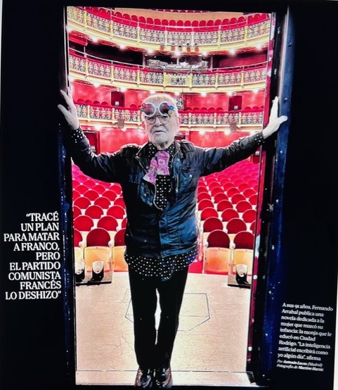 Fernando Arrabal sur une scène de théâtre. Il est debout, on voit la salle derrière lui.
