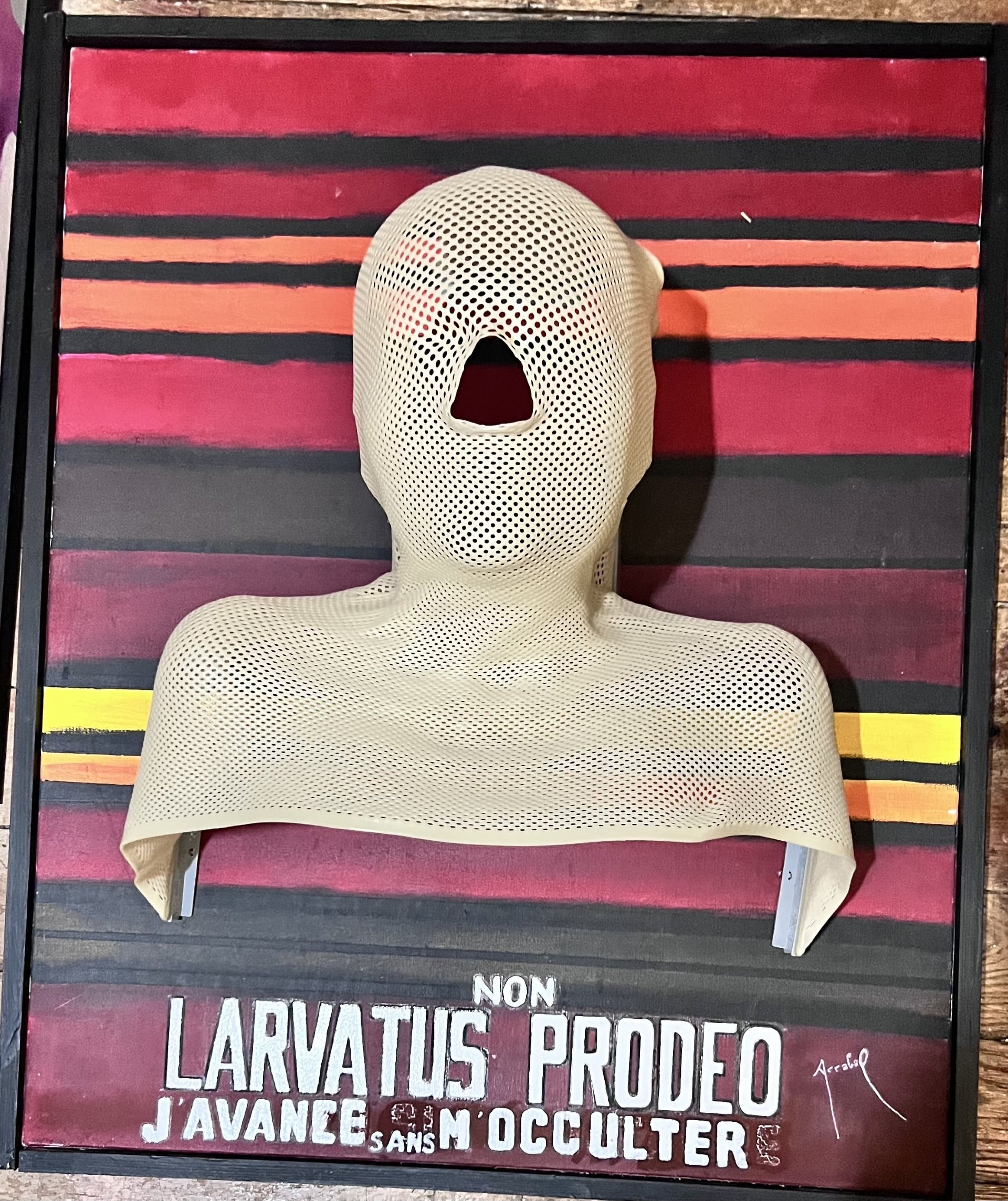 Tableau réalisé par Fernando Arrabal, sur des lignes colorées de rouges, rose et jaune, on voit un buste dont le nez est coupé.