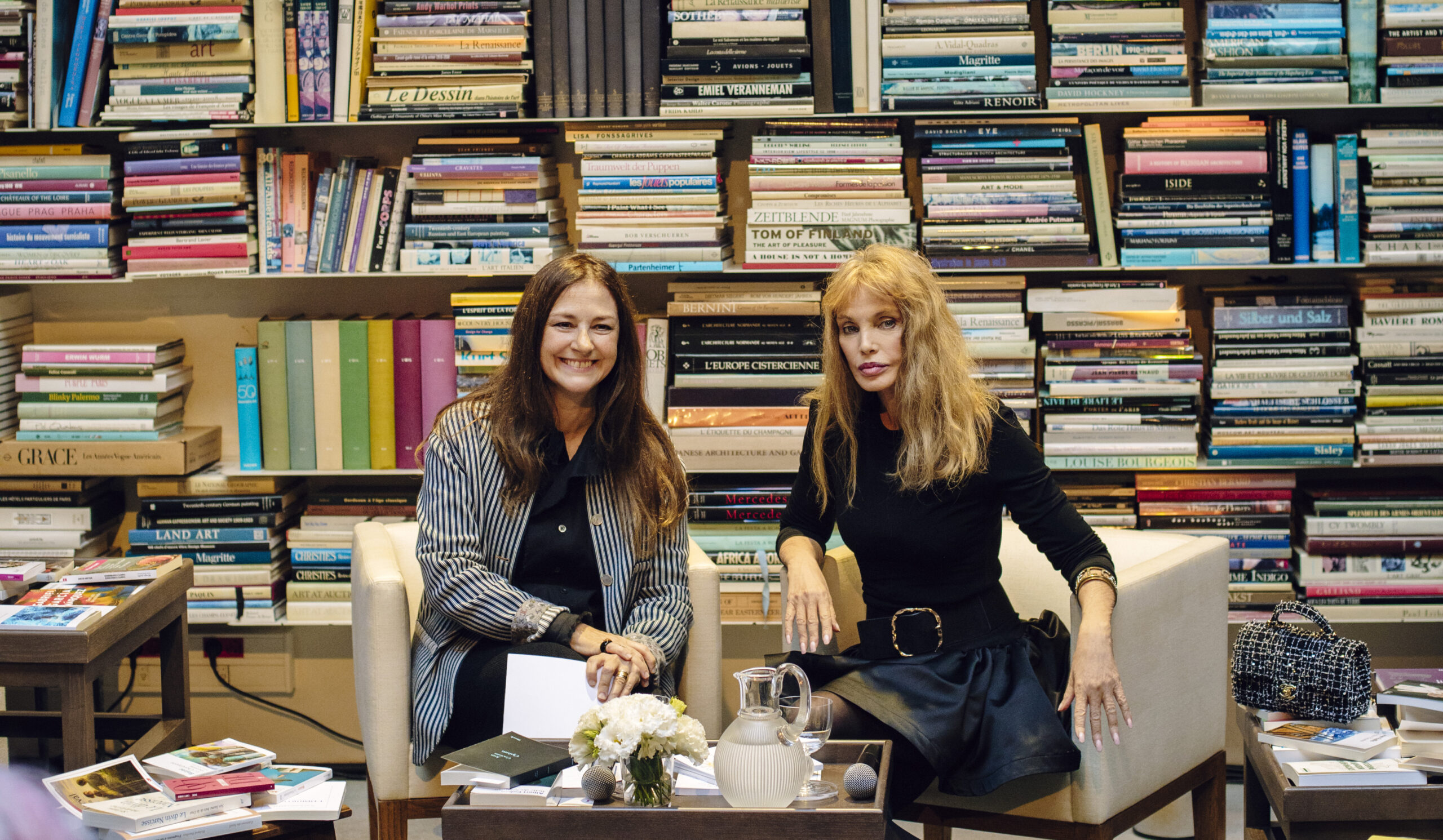 Laurence Delamare et Arielle Dombasle devant le mur de livres du studio-bibliothèque de Karl Lagerfeld.