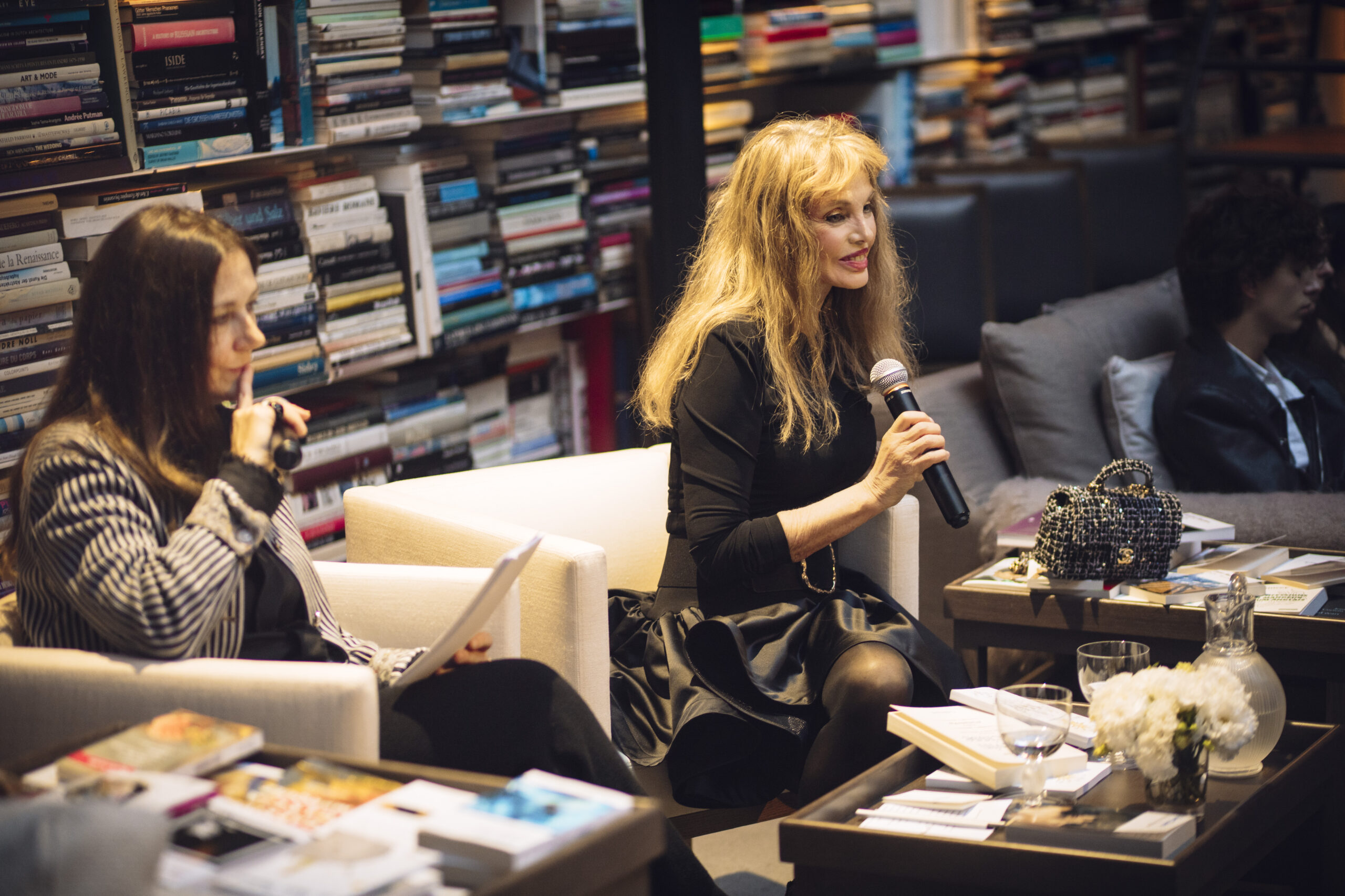 Laurence Delamare et Arielle Dombasle devant le mur de livres du studio-bibliothèque de Karl Lagerfeld.