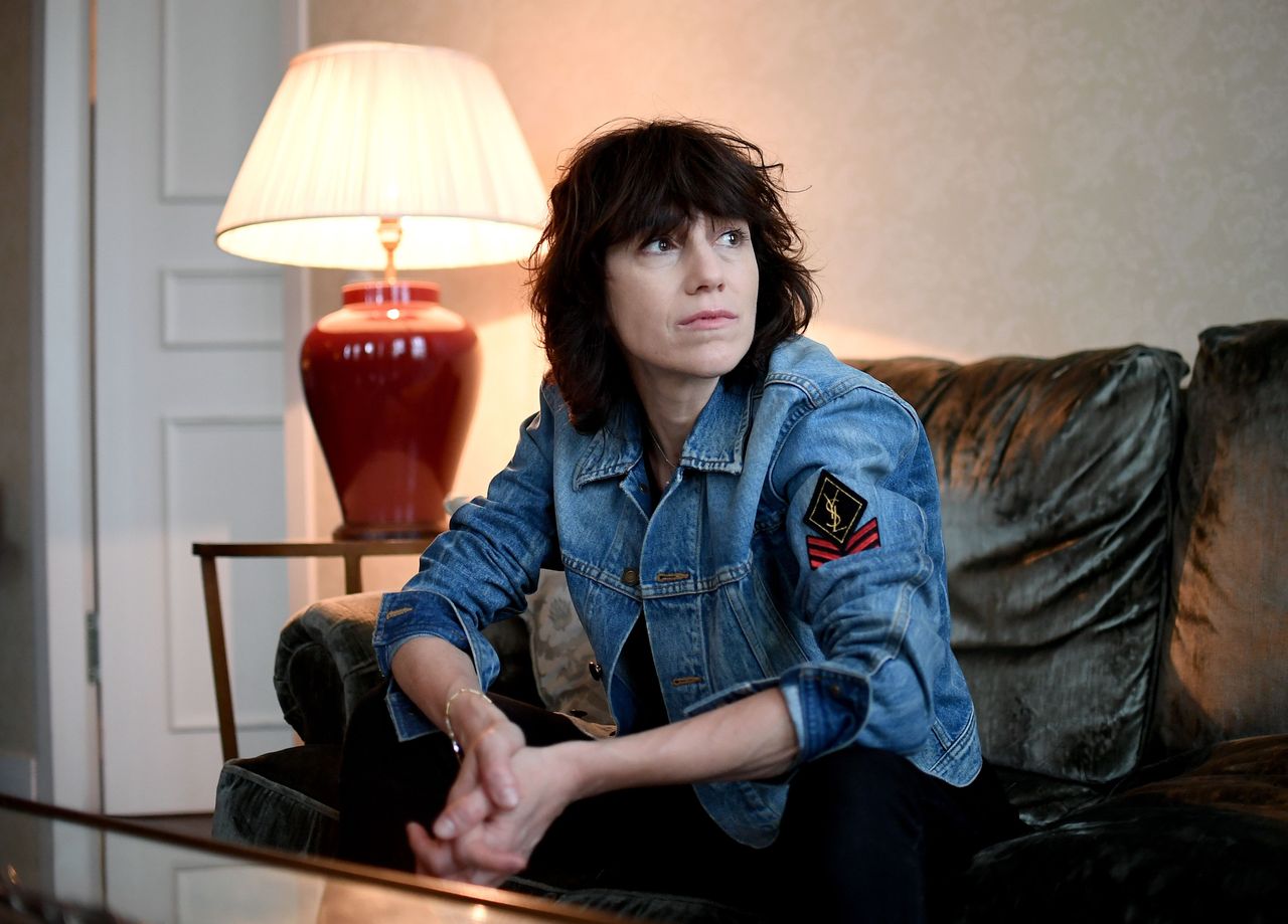 Photo de Charlotte Gainsbourg assise dans un canapé.