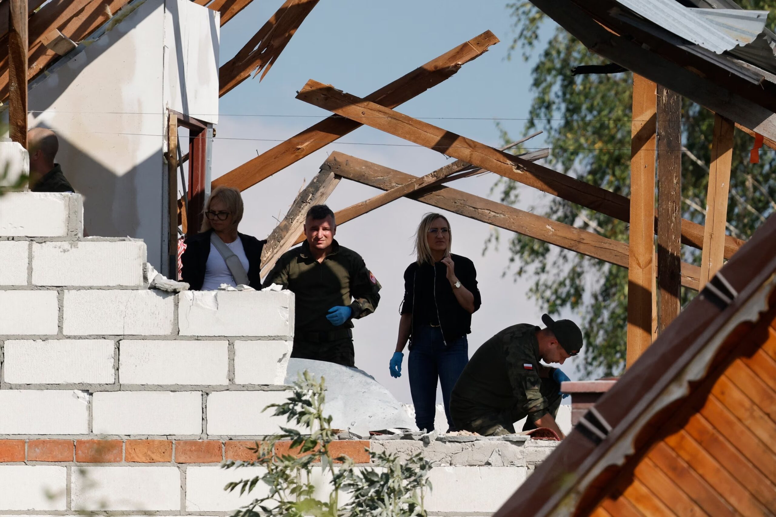 La police et l’armée inspectent les dégâts sur une maison détruite par des débris d’un drone russe abattu, dans le village de Wyryki-Wola