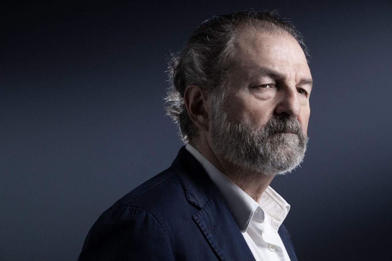 Portrait de Denis Olivennes devant un fond gris unis.