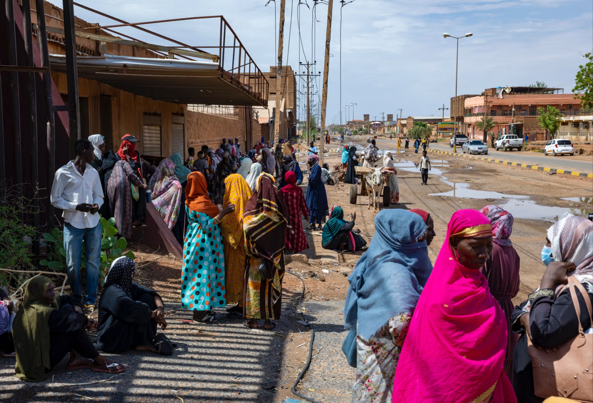 À Khartoum, des femmes attendent dans la rue une aide alimentaire qui ne vient pas.