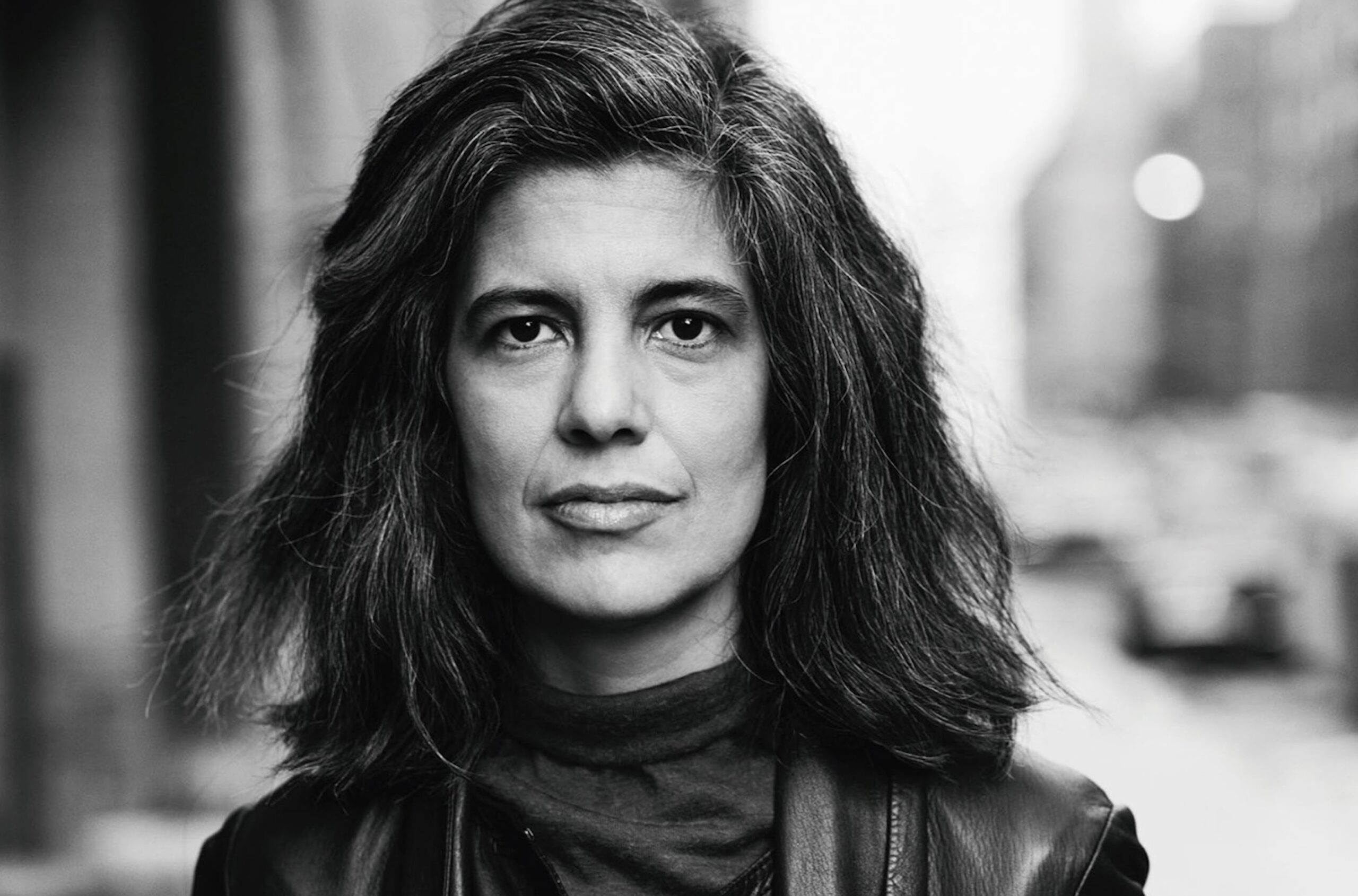 Portrait en noir et blanc de l’écrivaine américaine Susan Sontag, elle marche dans la rue.