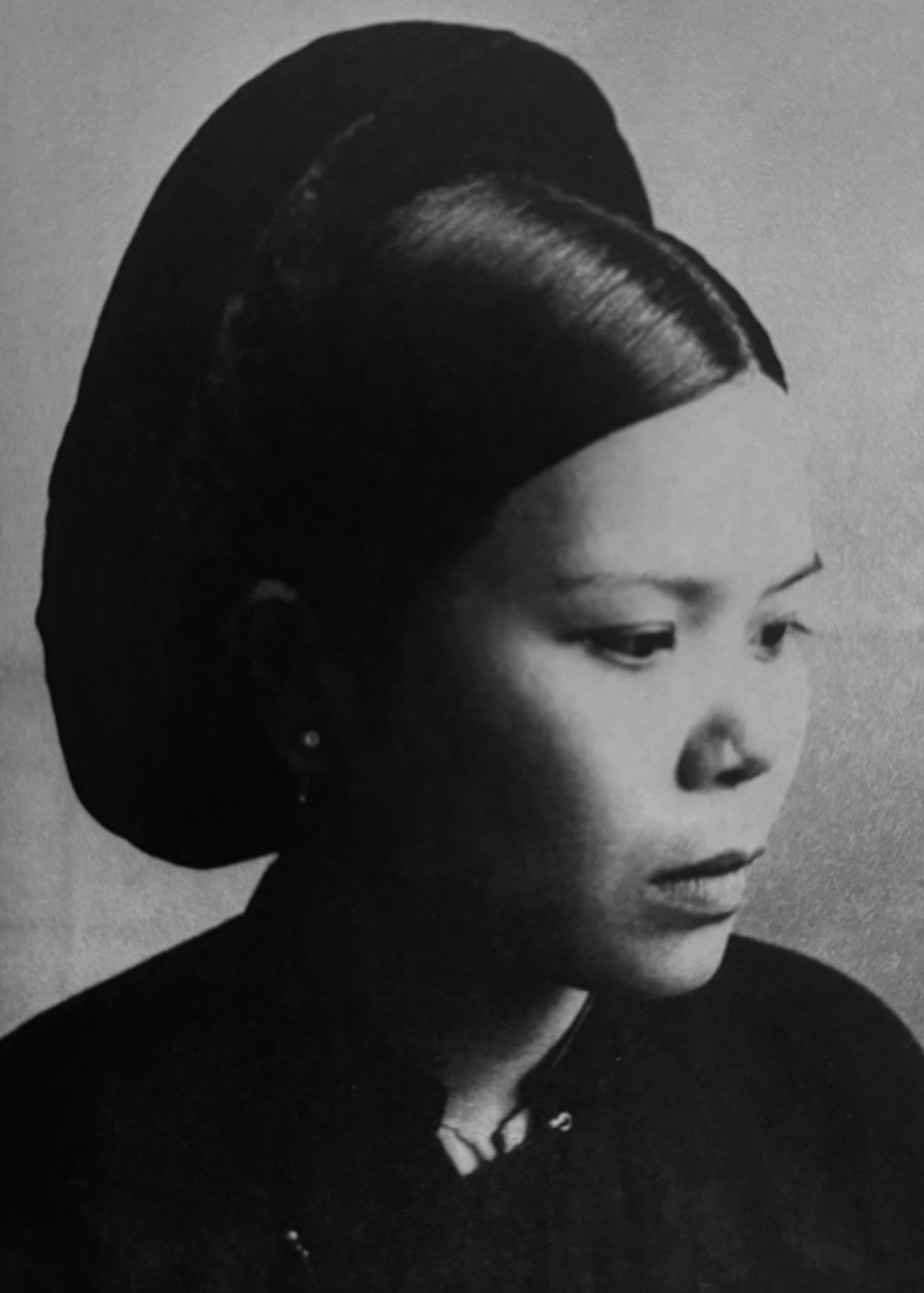 Portrait en noir et blanc d'une indochinoise des années trente, elle est vêtue de noir.
