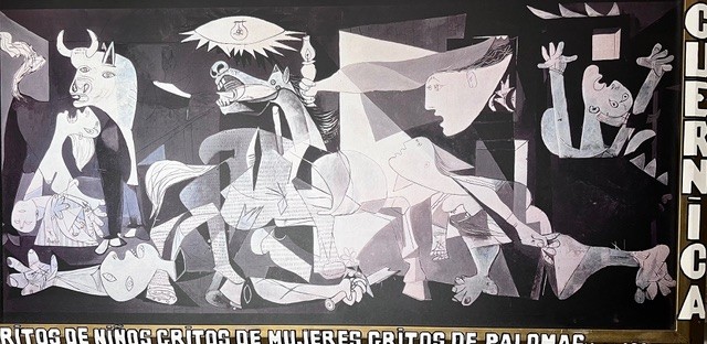 Peinture de Picasso connue sous le nom de Guernica. Fernando Arrabal y a ajouté, en bas de l’œuvre, le titre original de 1937 – « Gritos de niños, gritos de mujeres, gritos de caballos » – ainsi que, sur le bord droit du cadre, le titre imposé par Staline en 1944 : « Guernica ».