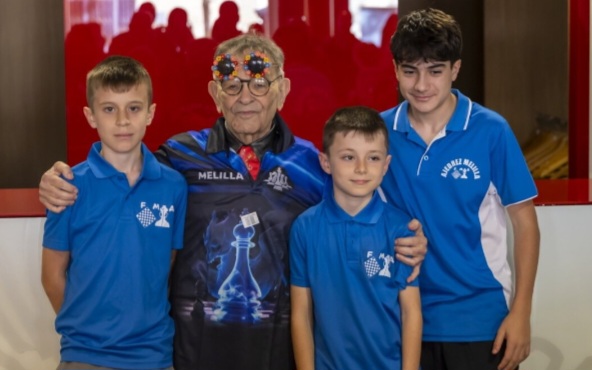 Fernando Arrabal lors d’un tournois d’échecs à Melilla, sa ville natale. Il est entouré de trois jeunes joueurs.