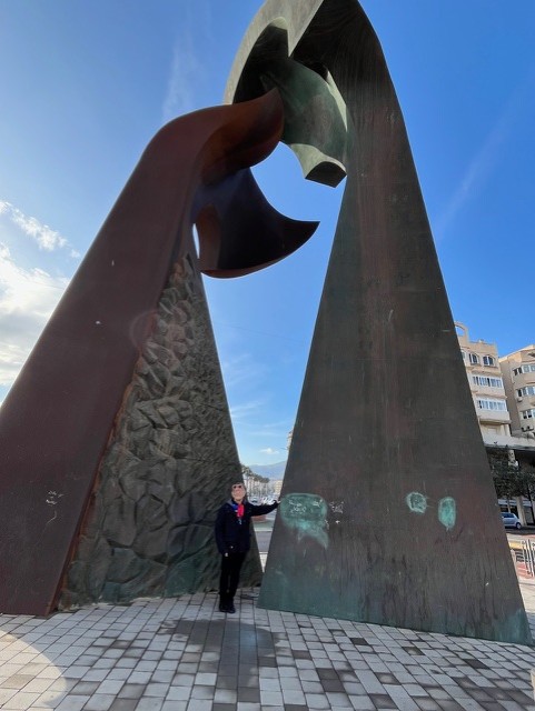 Fernando Arrabal sous la sculpture monumentale « Rencontre » de Mustafa Arruf, à Melilla, en Espagne.