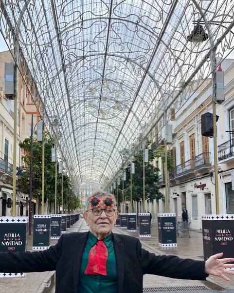 À Melilla, sa ville natale, Fernando Arrabal pose les bras ouverts sous des décorations de Noël.