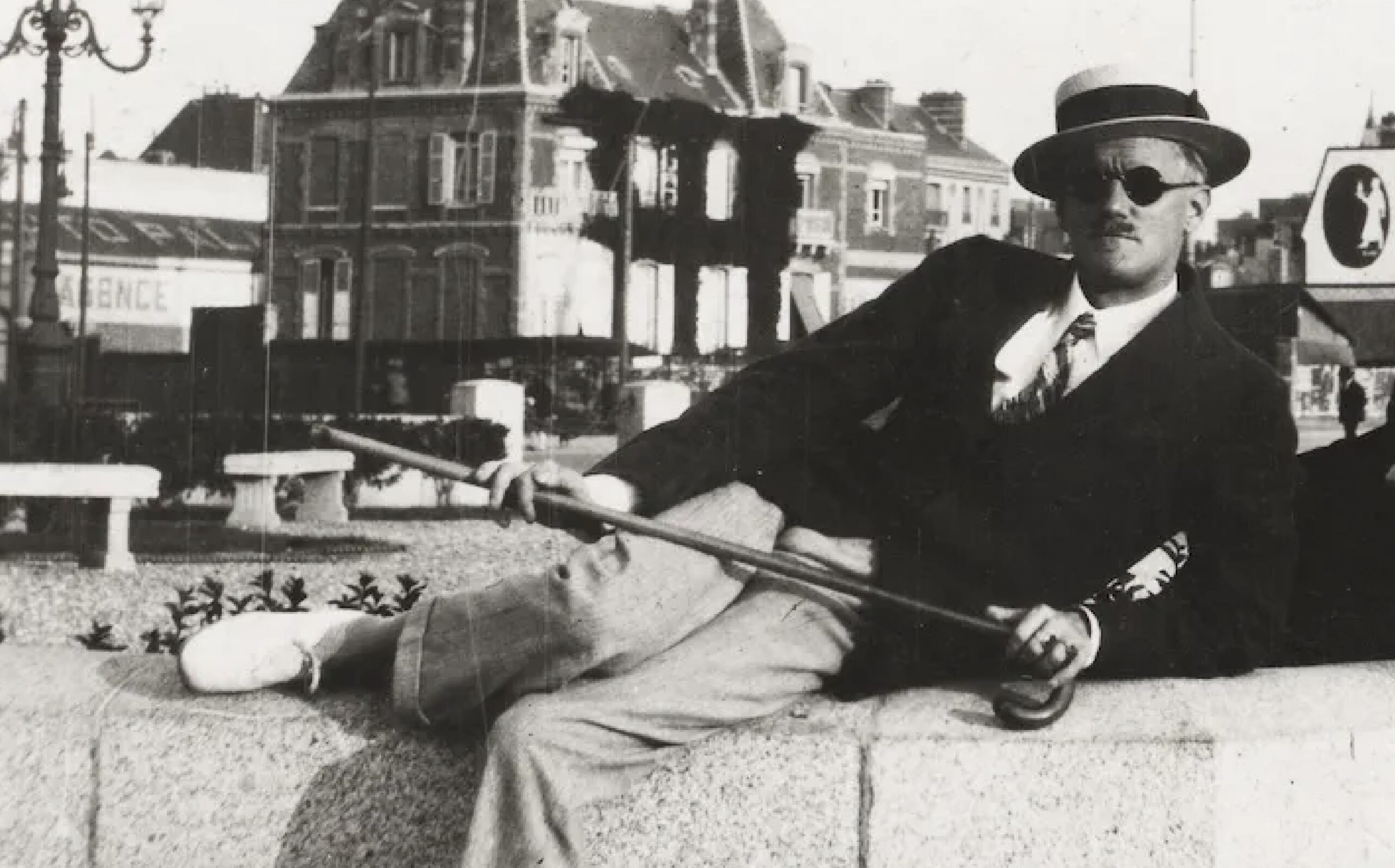 Photo en noir et blanc de James Joyce assis sur un muret à Zurich.