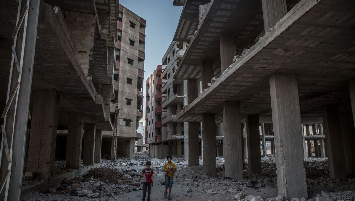 Une rue détruite en Syrie où l'on voit des enfants syriens courir.