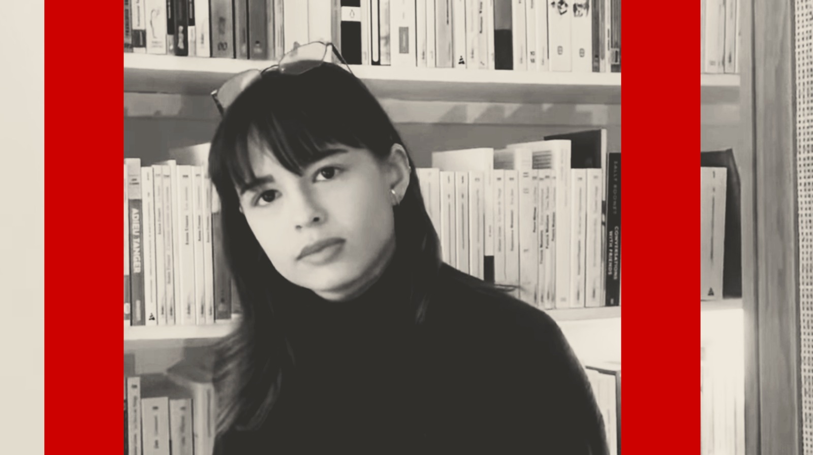 Emma Clairenbeaud pose devant une bibliothèque.