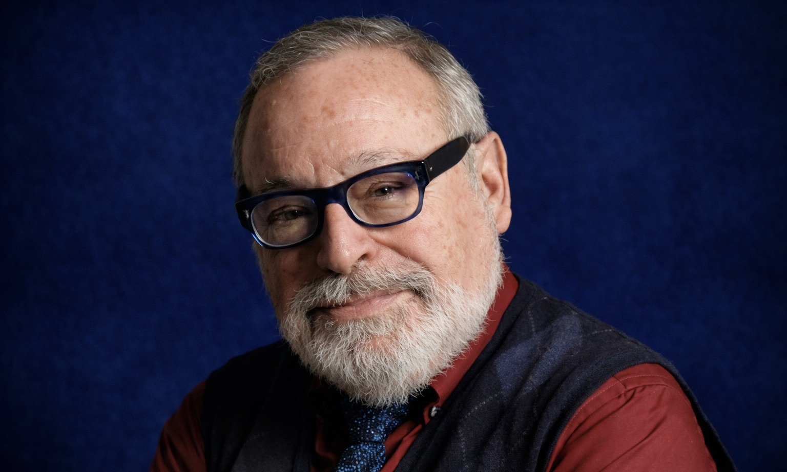 L’écrivain, essayiste et dramaturge espagnol Fernando Savater pose devant un fond bleu.