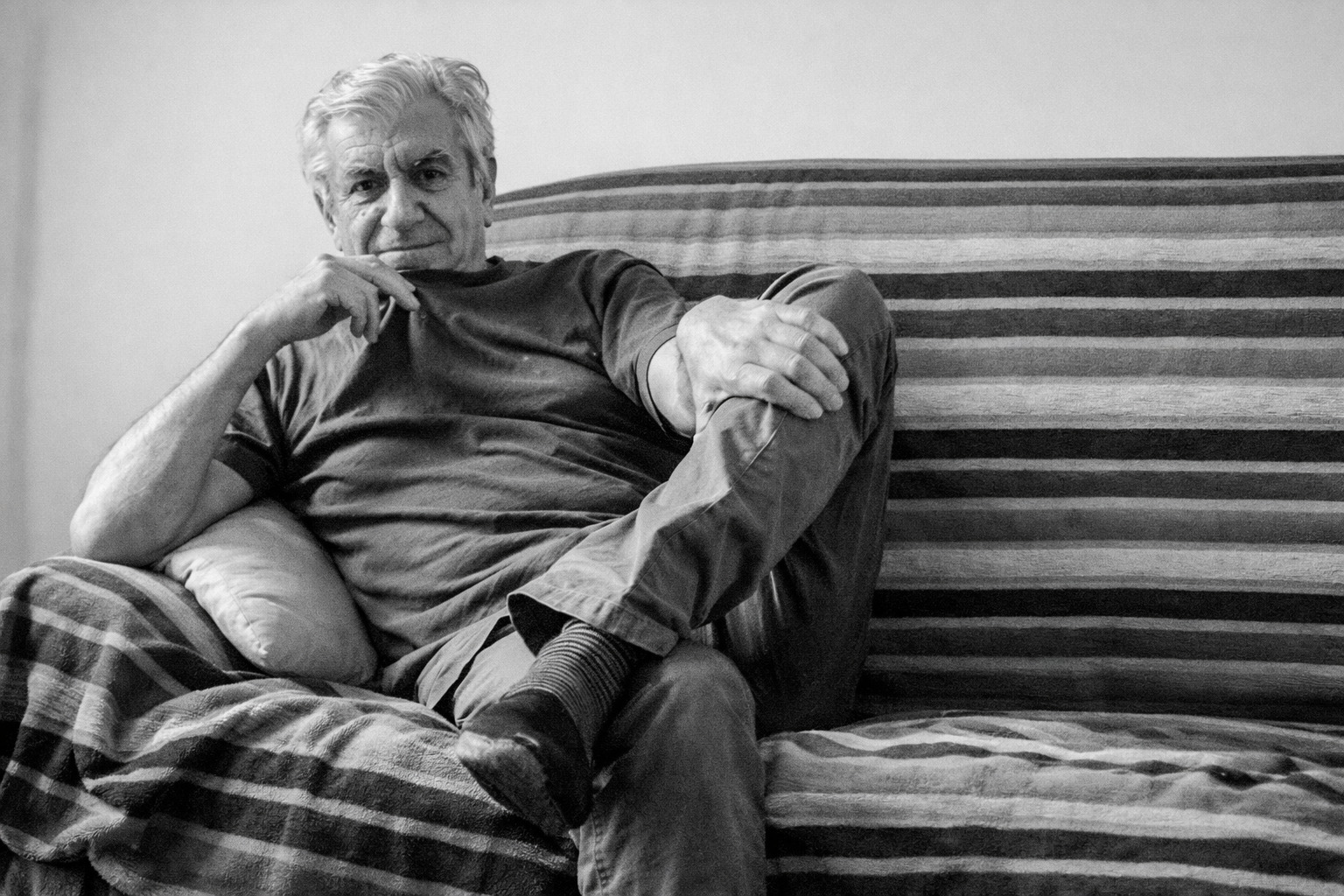 Photo en noir et blanc du philosophe Gérard Bensussan, assis dans un canapé.