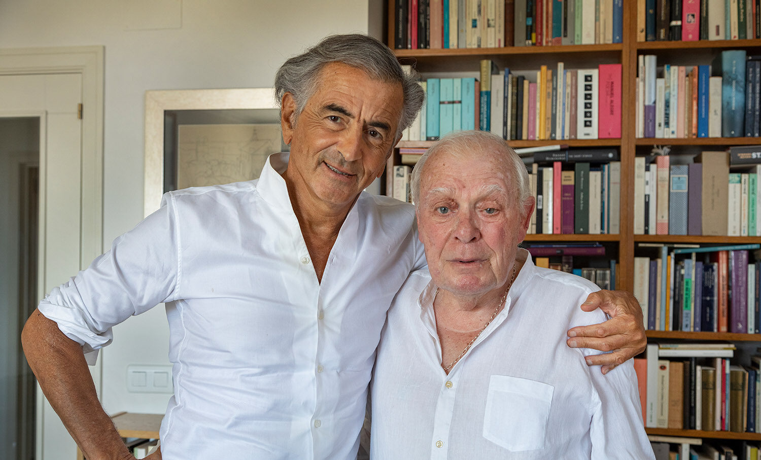 Bernard-Henri Lévy et son ami António Lobo Antunes devant une la bibliothèque de l'écrivain portugais.