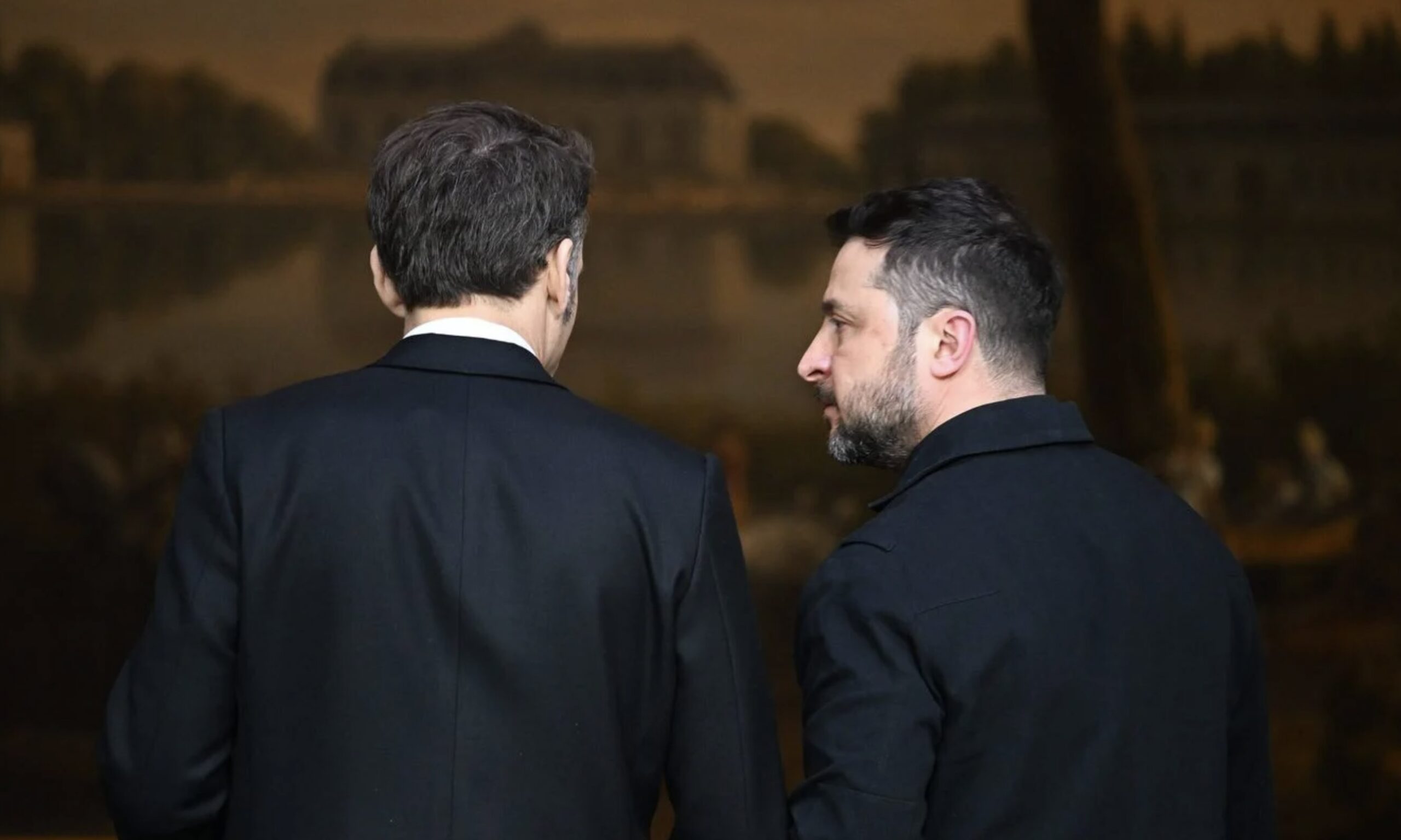 Emmanuel Macron et Volodymyr Zelensky lors d’une conférence de presse conjointe à l’Élysée. Ils sont côte à côte, on voit Macron de dos et Zelensky, de profil, le regarde.