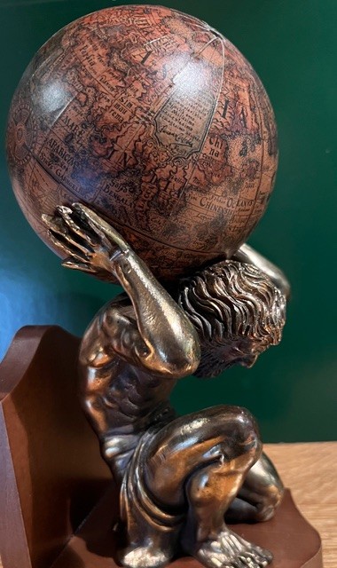 Statuette d'un homme qui porte le globe terrestre sur son dos.