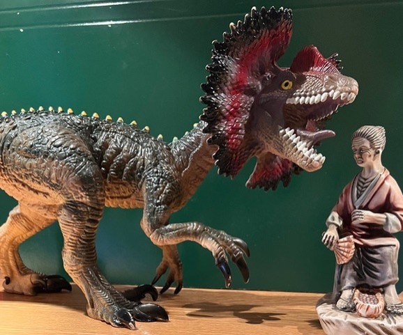Statuette d'un dinosaure et d'une vieille femme.