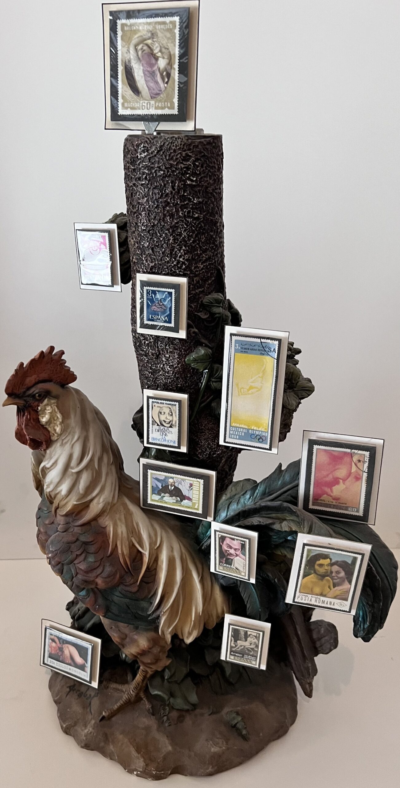 Poème plastique de Fernando Arrabal. Un coq décoratif sert de présentoir original à une collection de timbres encadrés.